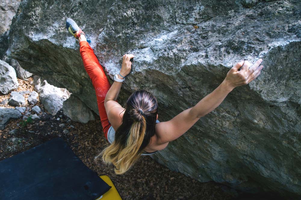 woman bouldering using a heel hook