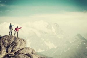 men pointing over mountain range