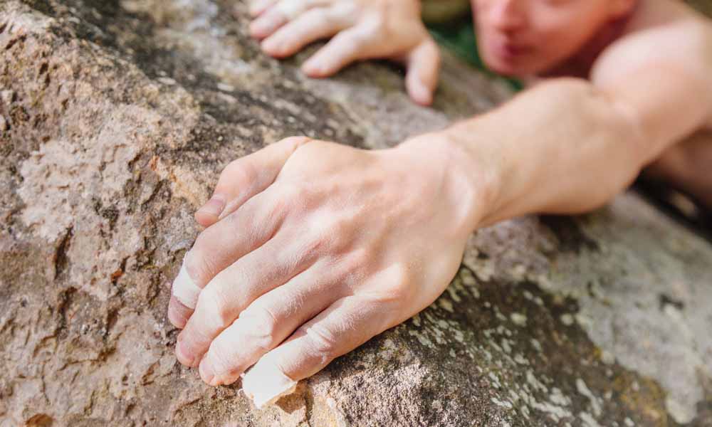man climbing with fingertape on 