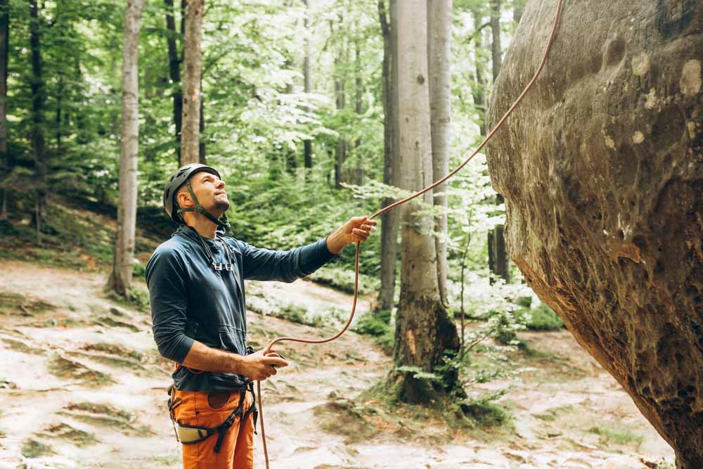 man belaying climber giving slack out