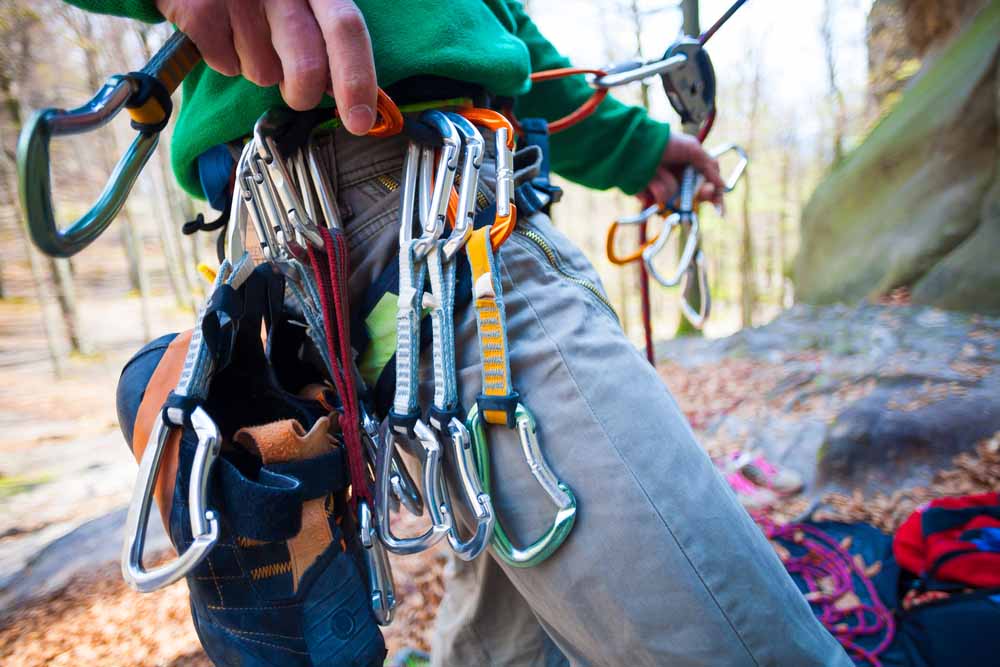 hand placing quickdraws on harness