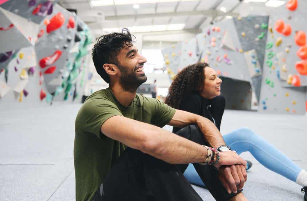 young man and woman laughing atthe bouldering gym