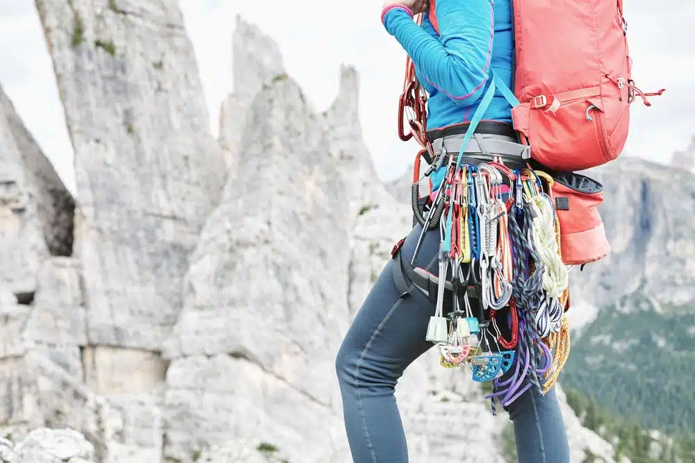 woman with harness and trad climbing gear