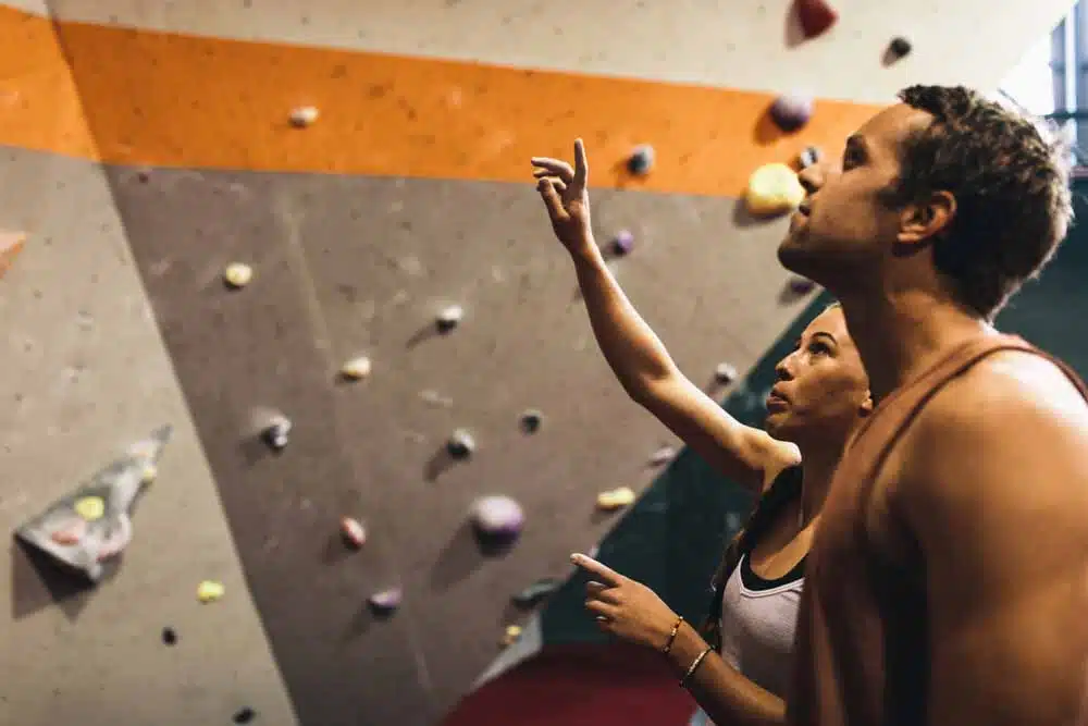 climbing coach gives pointers to male student