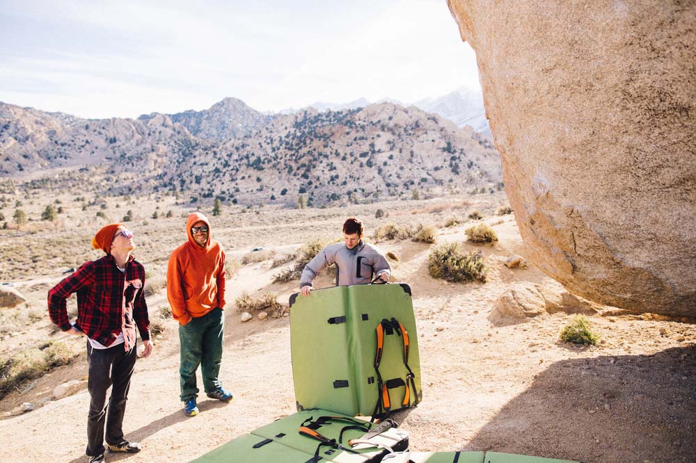 men opening crash pads for outdoor bouldering