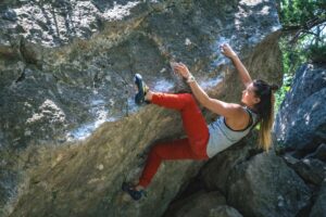 woman heel hooking while outdoor bouldering