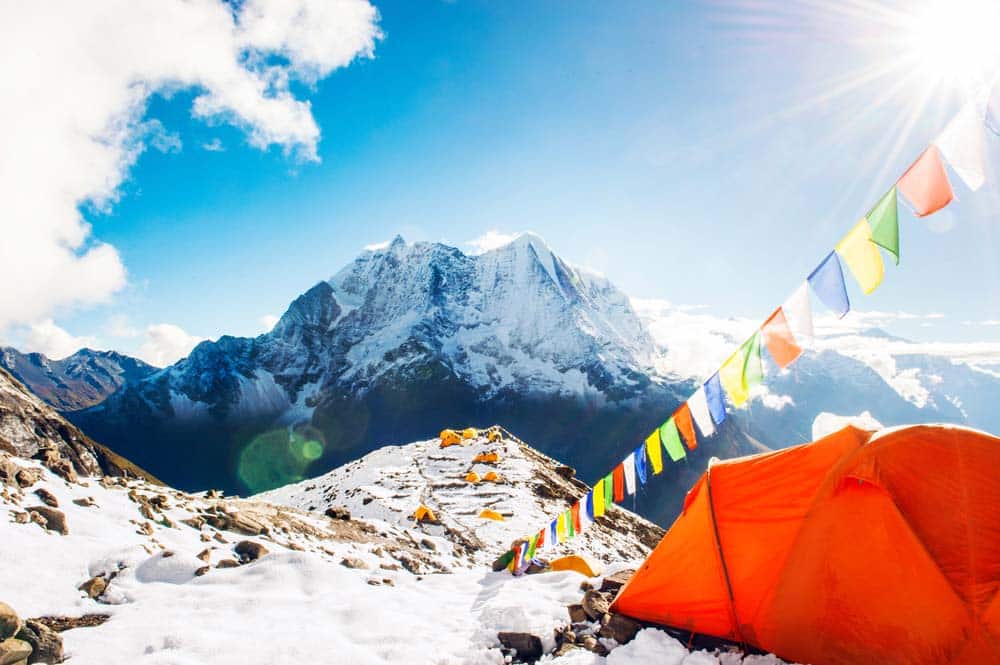 view of everest with prayer flags and tent