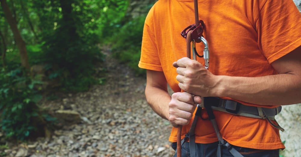 man using atc to hold climber