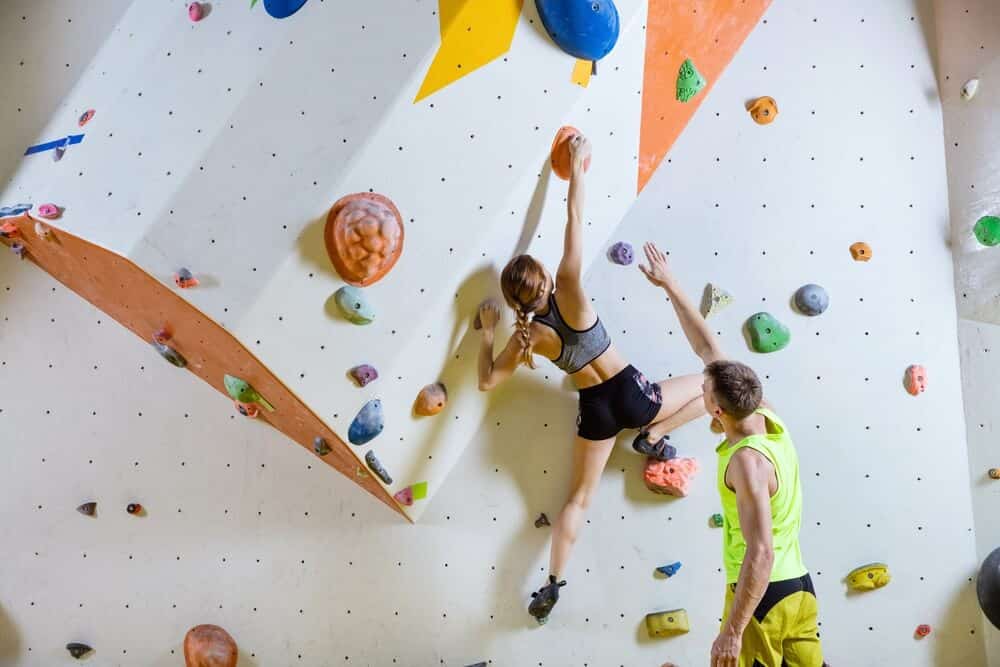 female climber with coach executing climbing training program