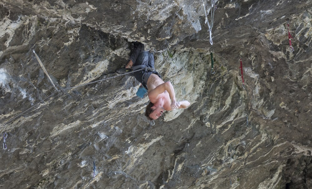 young man resting using a double kneebar on roof