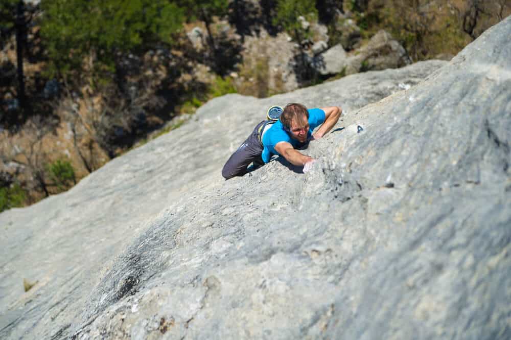 young man performing free solo climbing outdoors