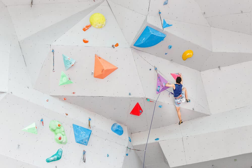 young man lead climbing on artificial wall
