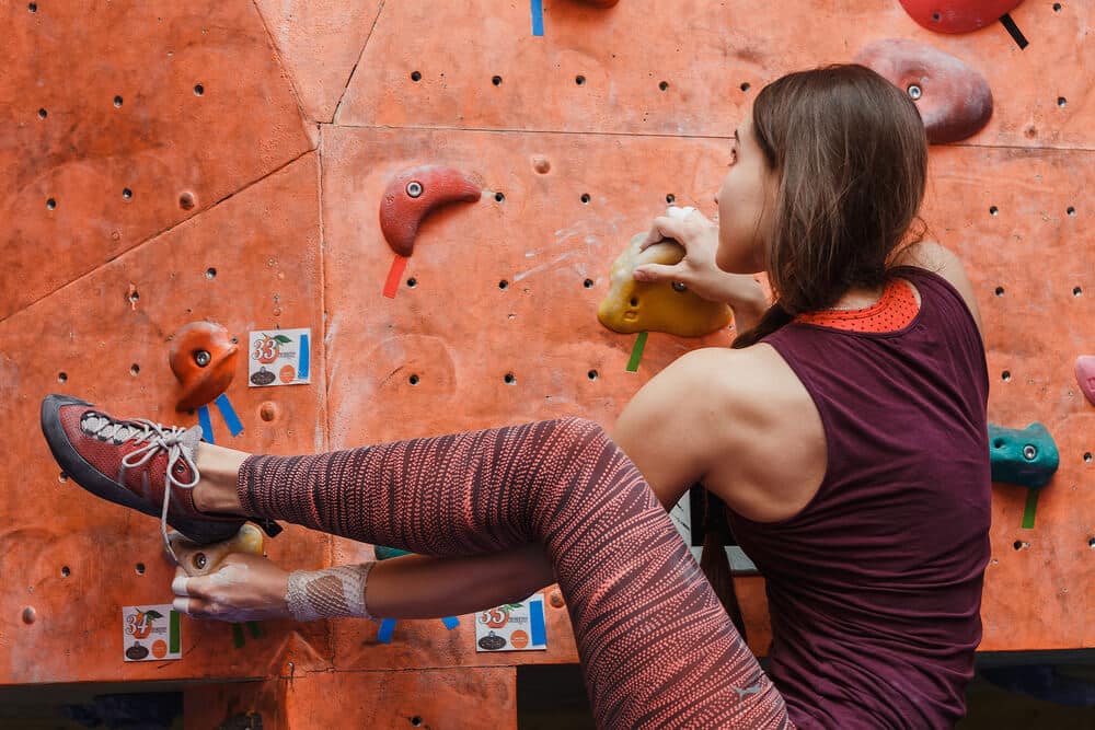 woman bouldering rocking over foot