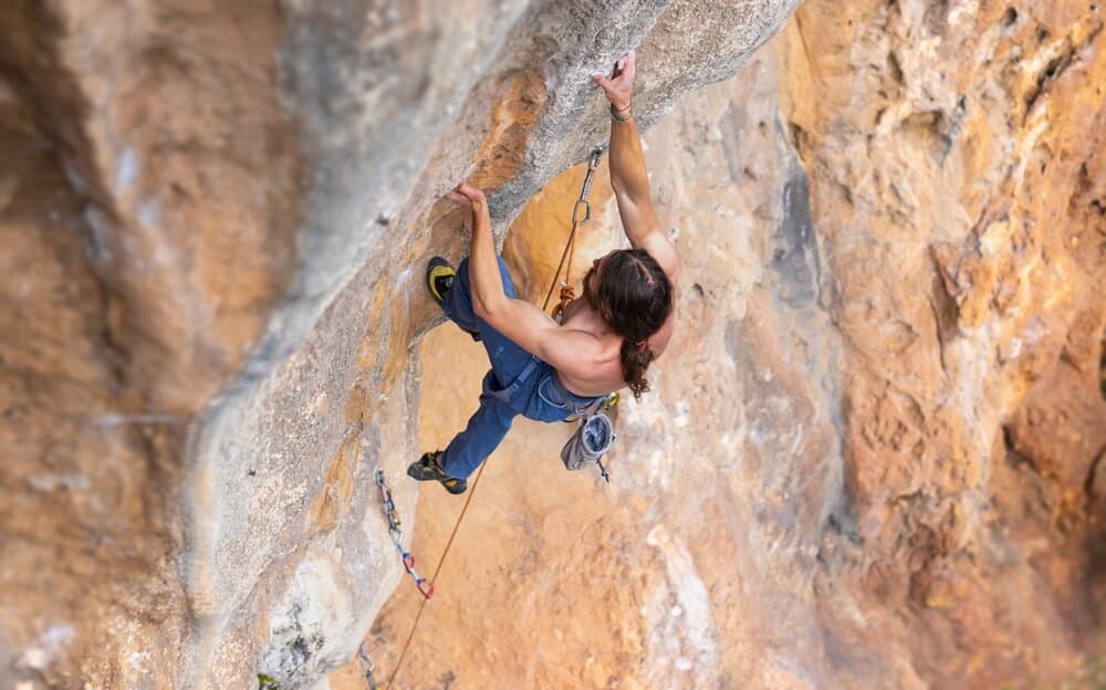 man on overhanging tufas smearing with left foot