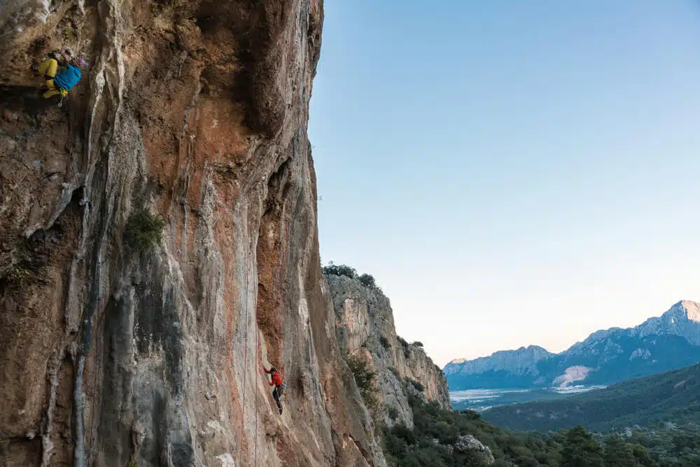 people climbing with view over mountains behind