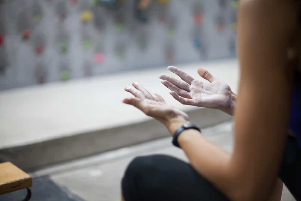 woman loking at chalk on hands