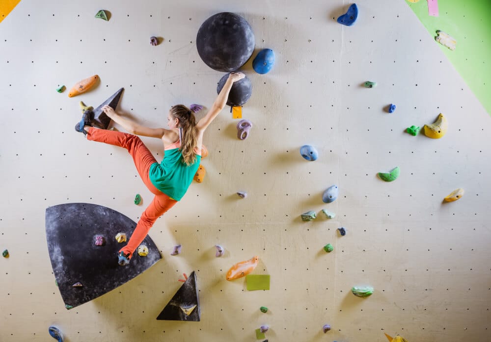 woman training power endurance when bouldering indoors