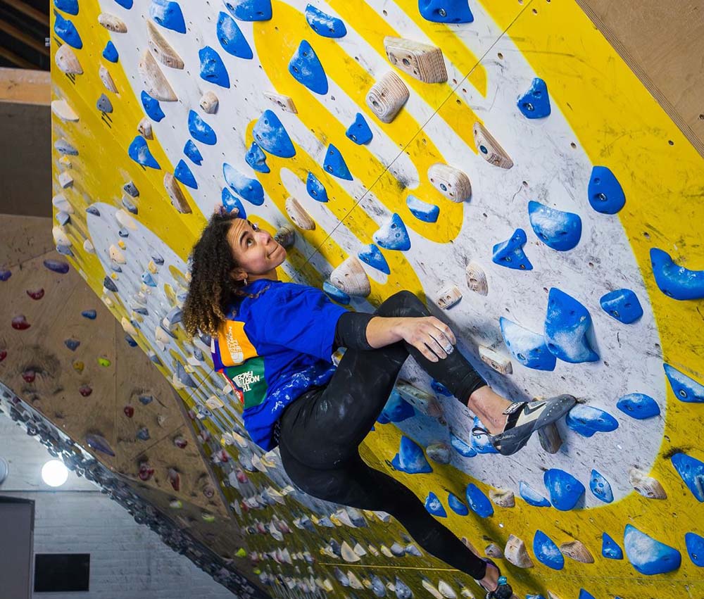 female climber using a moonboard to train bouldering