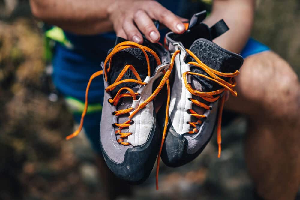 climber hold pair of lace-up climbing shoes