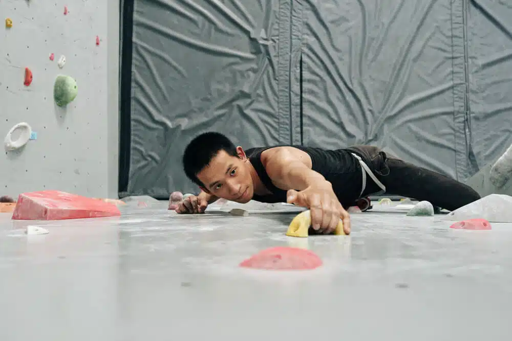 male asian climber practicing indoors
