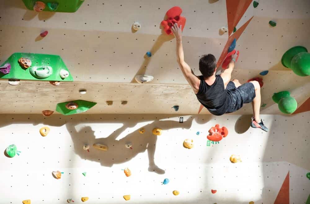 male climber on indoor bouldering steep wall